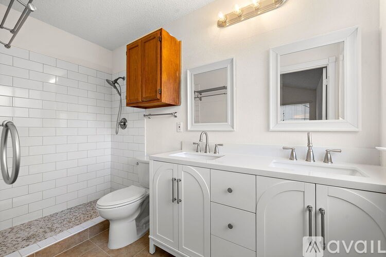 A bathroom with a toilet, sink, and mirror.