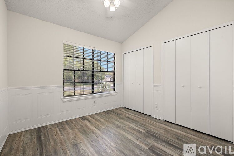 A room with a window and wooden flooring.