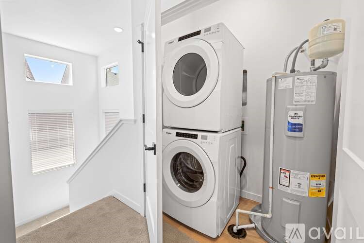 A washing machine is in a small room with a carpeted floor.