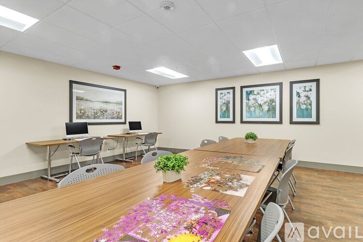 A conference room with a long table, chairs, and pictures on the wall.