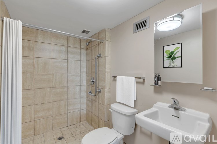 A bathroom with a toilet, sink, and shower.