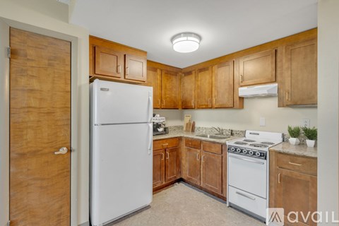 A kitchen with wooden cabinets and a white refrigerator.