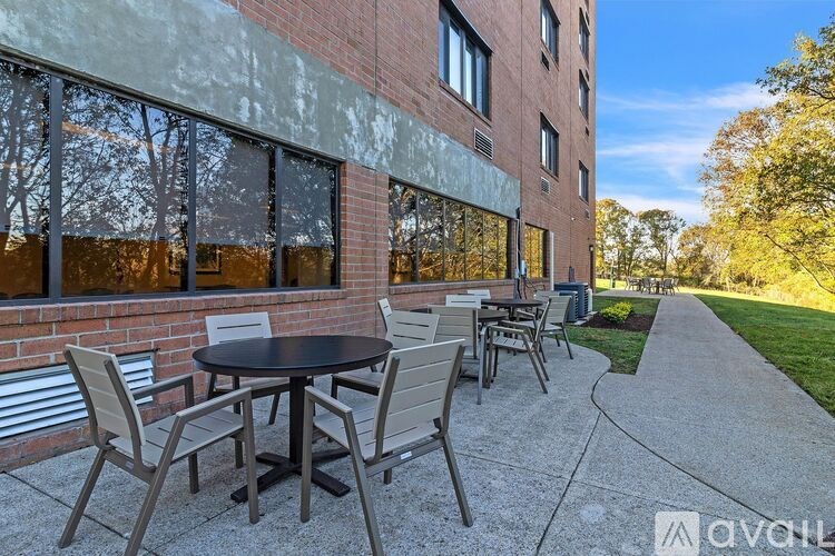 A patio with a table and chairs is in front of a brick building.