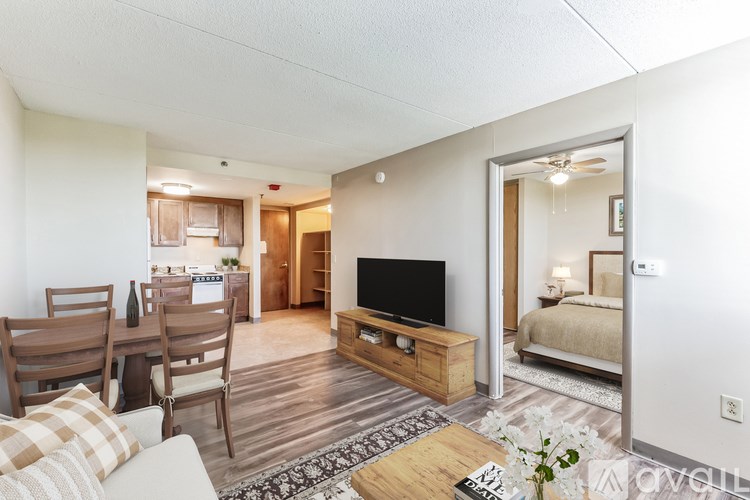 A living room with a couch, chairs, a coffee table, and a television.