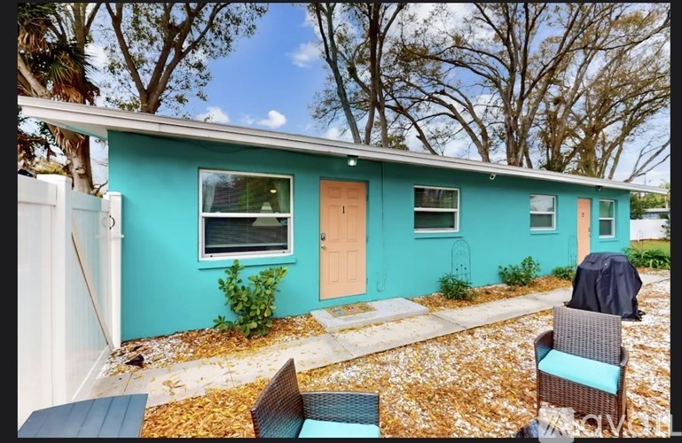 A blue house with a brown door and a small porch.