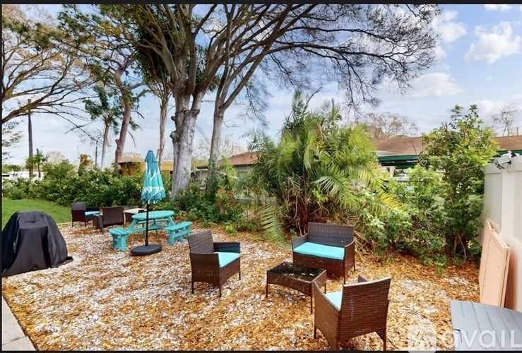 A patio with a table and chairs surrounded by trees.