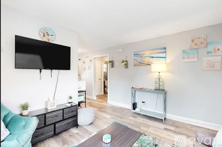 A living room with a flat screen TV mounted on the wall.