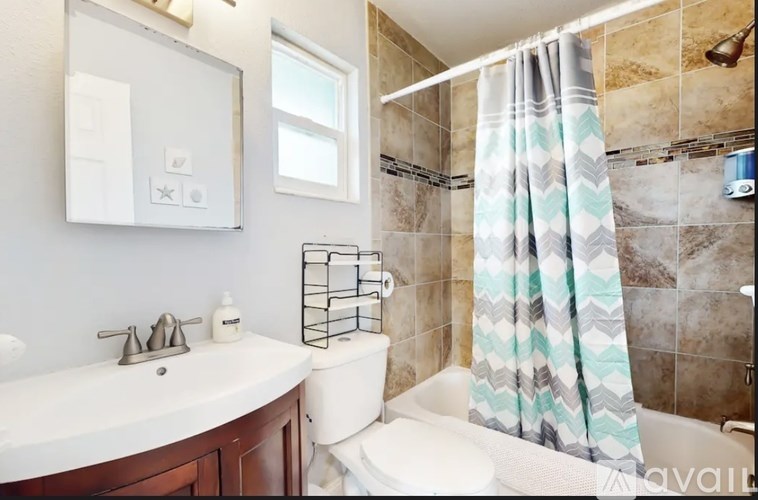 A bathroom with a white sink, toilet, and shower curtain.