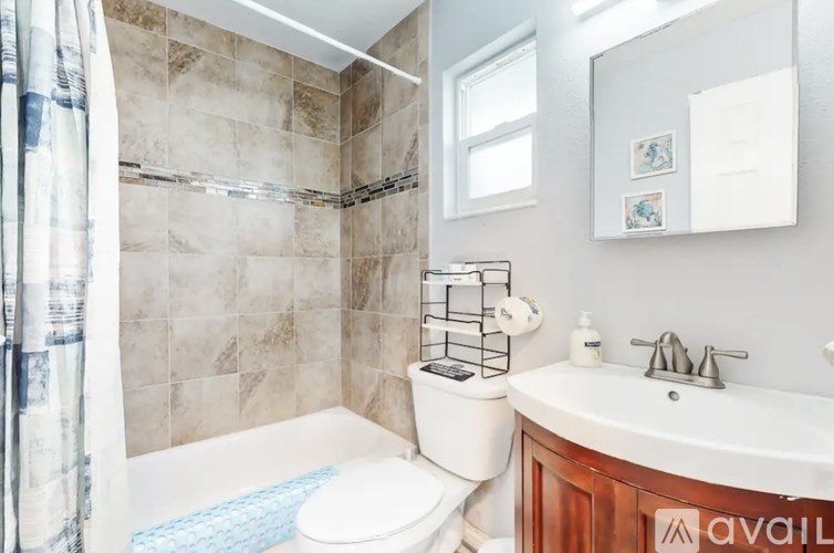A bathroom with a toilet, sink, and shower.