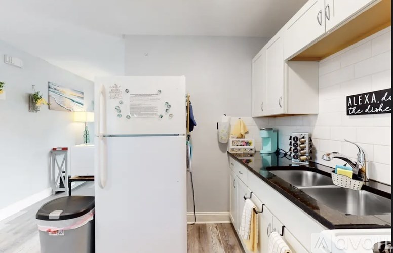 A kitchen with a white fridge and white cabinets.