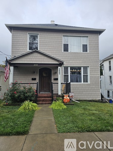 A house with a grey facade and a brown door is shown.