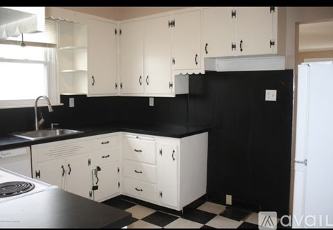 A kitchen with black countertops and white cabinets.