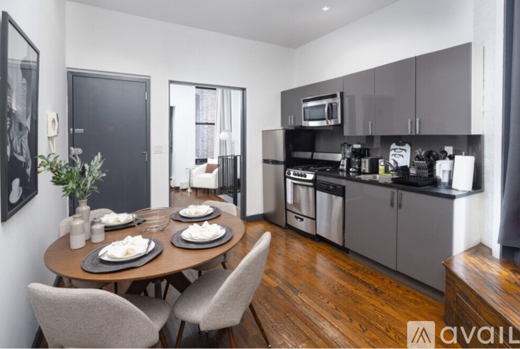 A kitchen with a table set for two and a dining area.