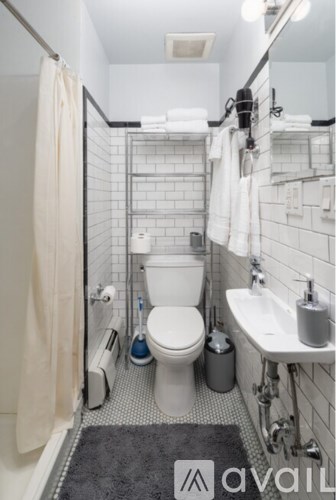 A bathroom with a toilet, sink, and shower.