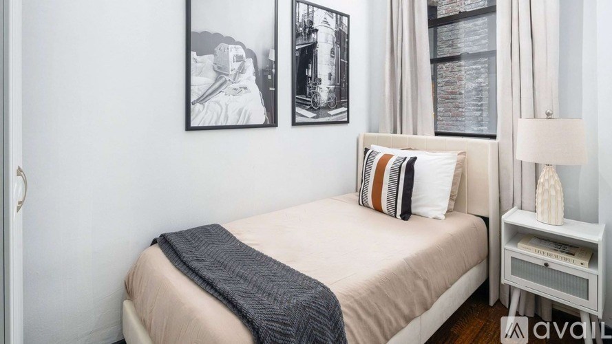 A bedroom with a bed, nightstand, and pictures on the wall.