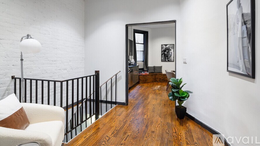 A living room with a white couch and a wooden floor.
