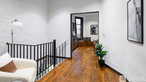 A living room with a white couch and a wooden floor.