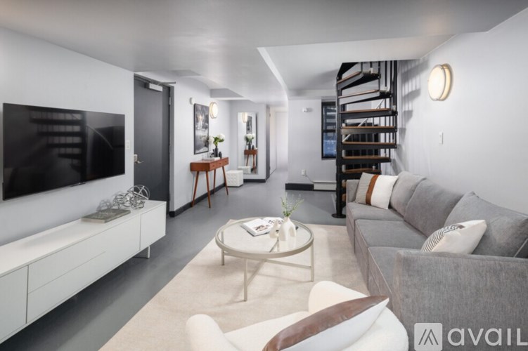 A modern living room with a grey sofa and a white coffee table.