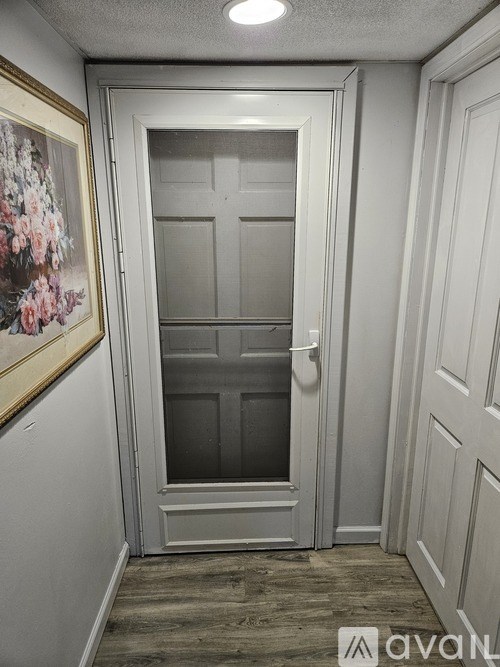 A white door with a glass panel is in a room with white walls.