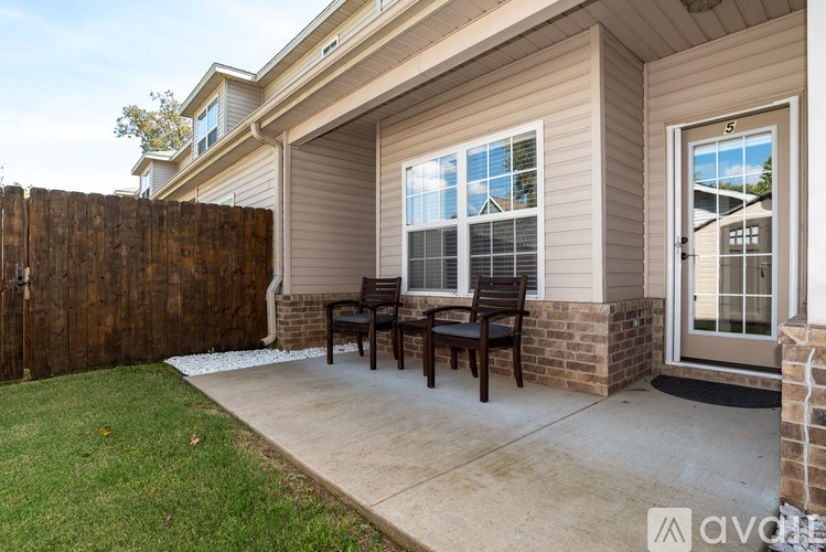 A house with a brown fence and a brown bench outside.