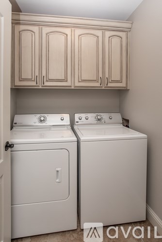 Two white front loading washing machines in a laundry room.