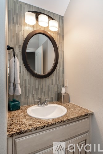 A bathroom with a round mirror and a sink.