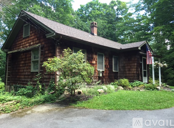 A house with a brown wooden exterior and a green window.