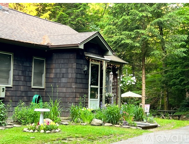 A small house with a green lawn in front.
