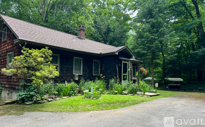 A house with a brown roof and a green lawn in front.