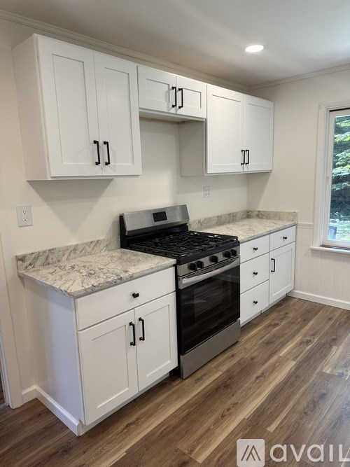 A kitchen with white cabinets and a granite countertop.