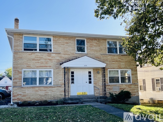 A two-story brick house with a white door and windows.