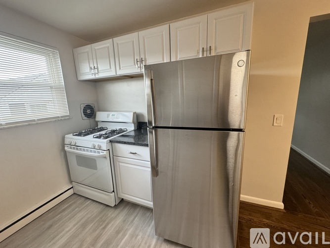 A kitchen with white cabinets and a black countertop.