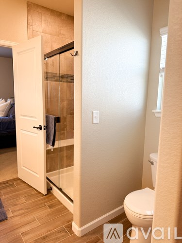 A white door is open to a bathroom with a toilet.