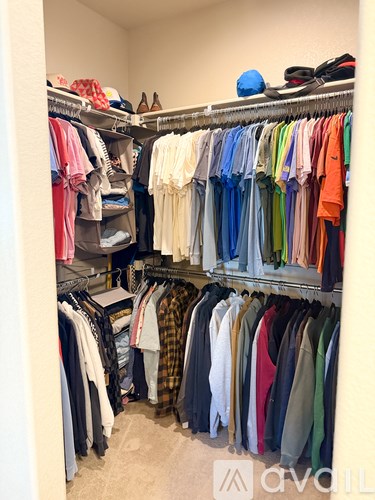 A closet full of clothes on shelves and hanging.