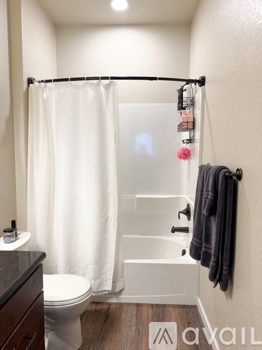 A white toilet sits next to a white bathtub in a small bathroom.