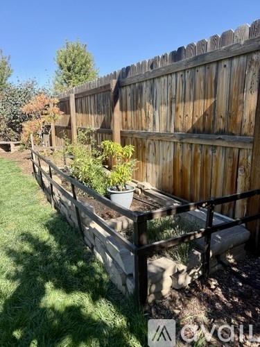 A wooden fence with a metal railing and a planter box.