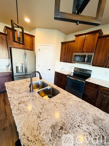 A kitchen with a granite countertop and wooden cabinets.