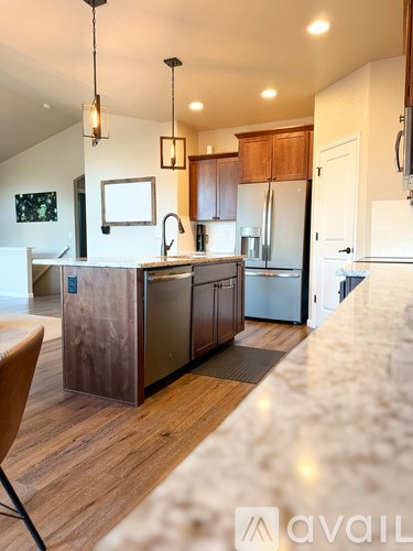 A kitchen with wooden cabinets and a marble countertop.