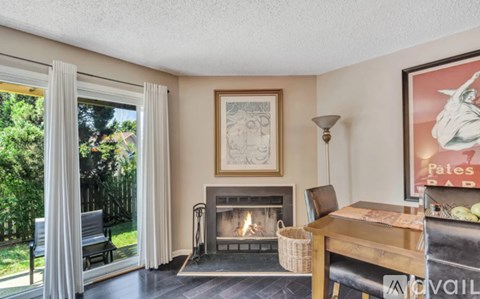 A living room with a fireplace and a painting on the wall.