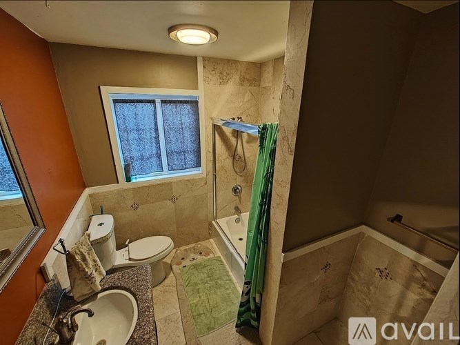 A bathroom with a toilet, sink, and bathtub.