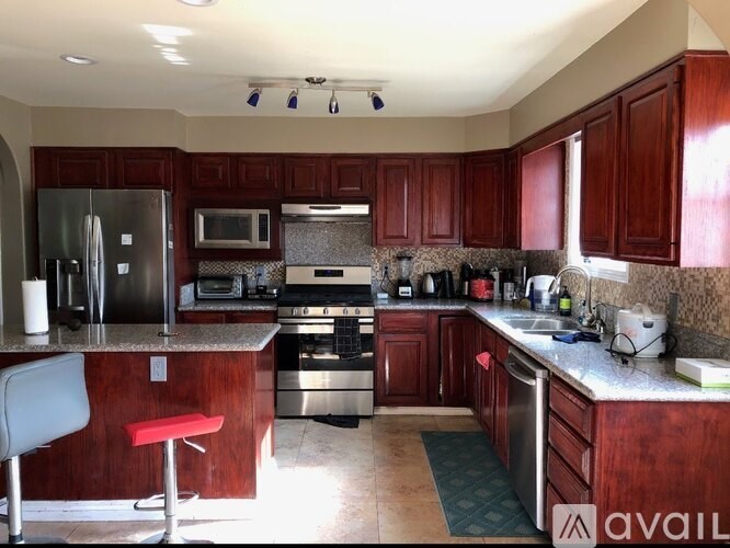 A kitchen with wooden cabinets and a stainless steel refrigerator.