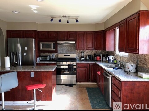 A kitchen with wooden cabinets and a stainless steel refrigerator.