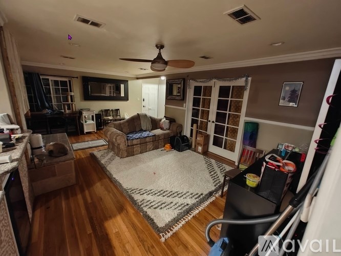 A living room with a couch, a chair, and a rug.