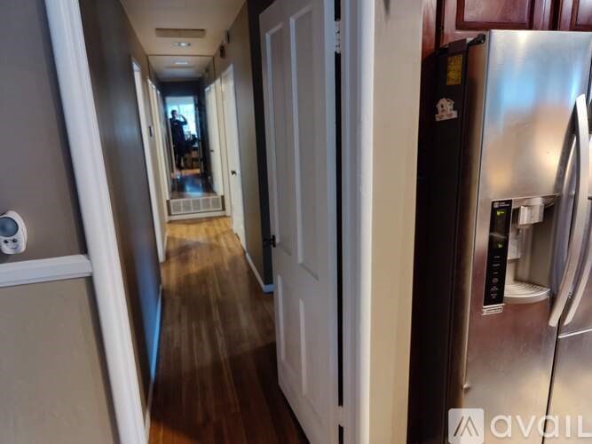 A long hallway with a refrigerator on the right.