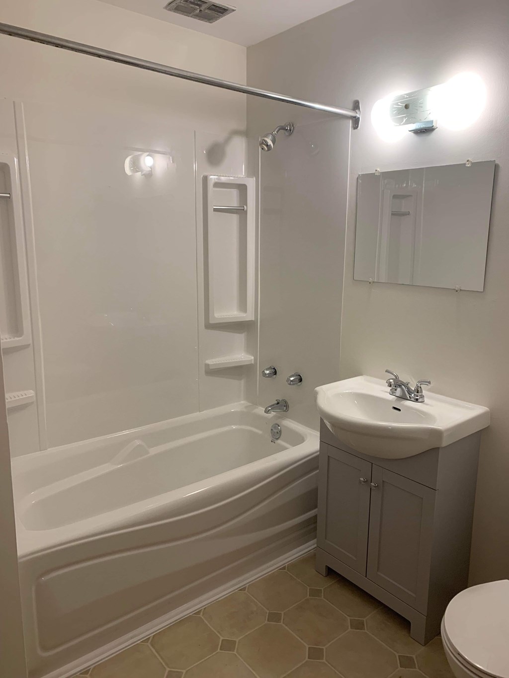 A white bathroom with a sink, toilet, and bathtub.