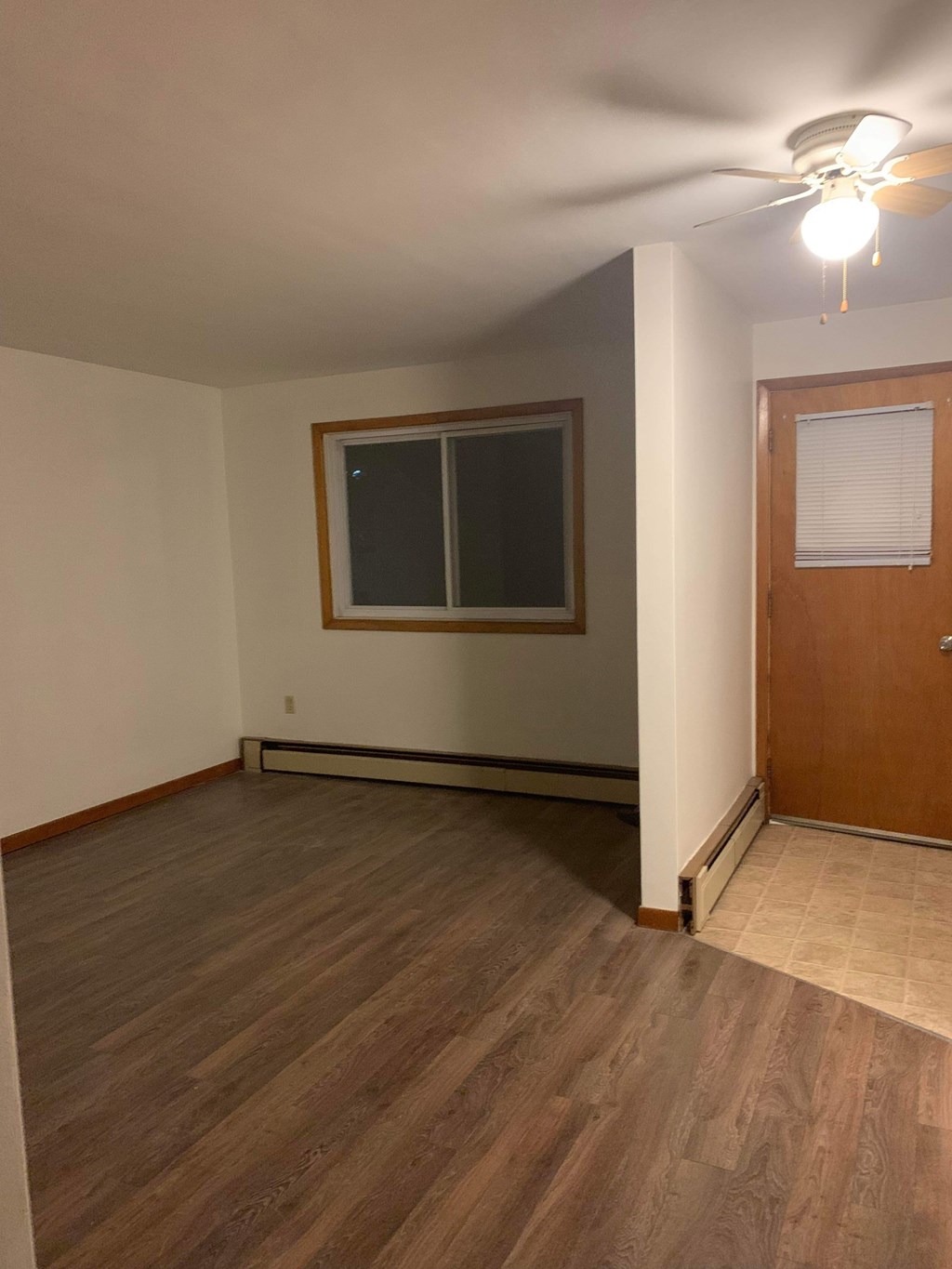 A room with a wooden floor and a ceiling fan.