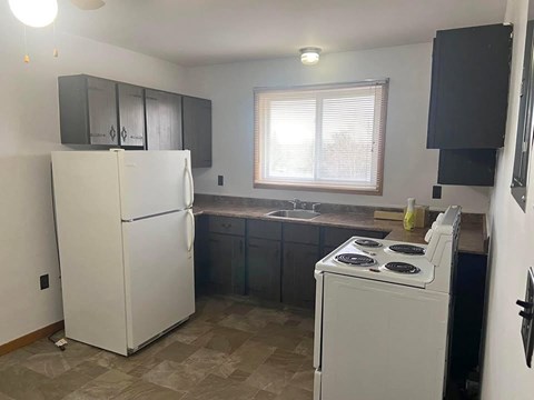 A kitchen with a white fridge and a white stove.