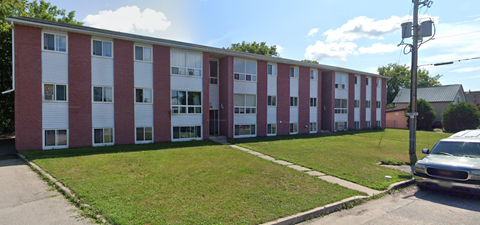 A red and white building with a green lawn in front.