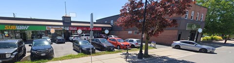 A parking lot with cars and a Subway restaurant in the background.