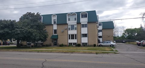 A building with a green roof and white trim is in the background.